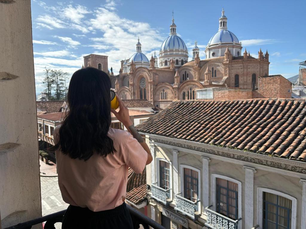 a woman talking on a cell phone looking at a building at Casa Vega in Cuenca