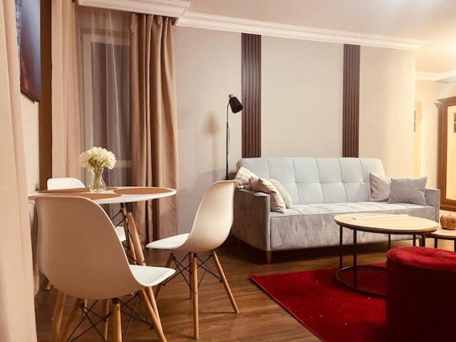 a living room with a couch and a table and chairs at Apartament Prestige Zawiercie in Zawiercie