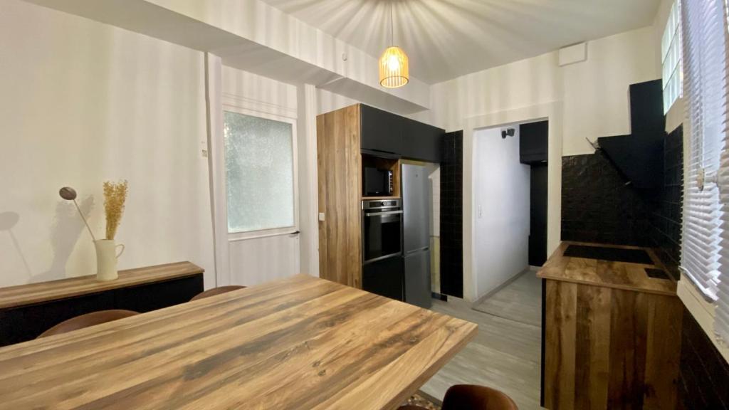 a kitchen with a wooden table in a room at POITTE - Appartement Rennes 10P in Rennes