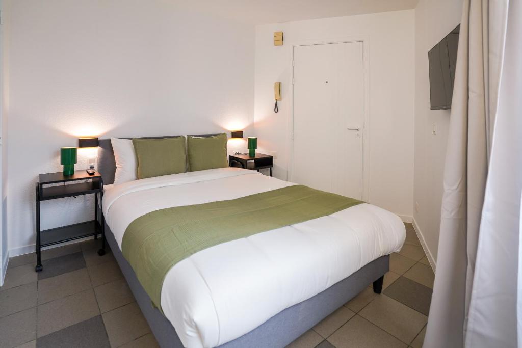 een slaapkamer met een groot bed met twee nachtkastjes bij La Chasse 5 in Brussel