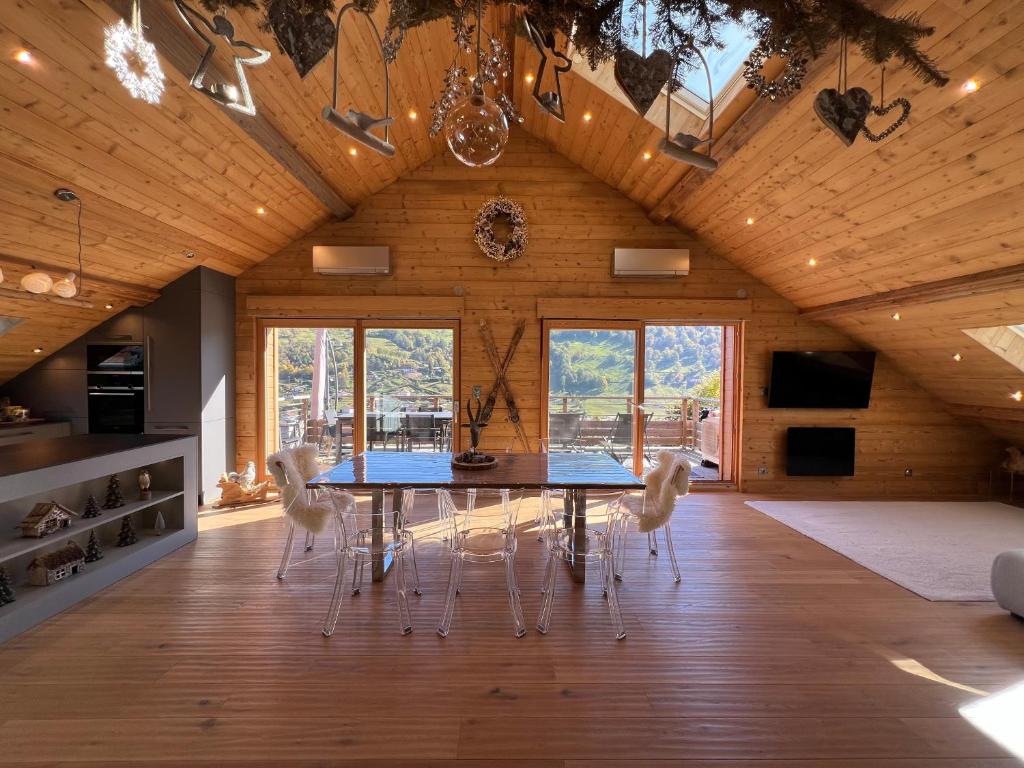 a dining room with a table and chairs at Splendide appartement style chalet classé 4 étoiles, terrasse face à la montagne in La Bresse