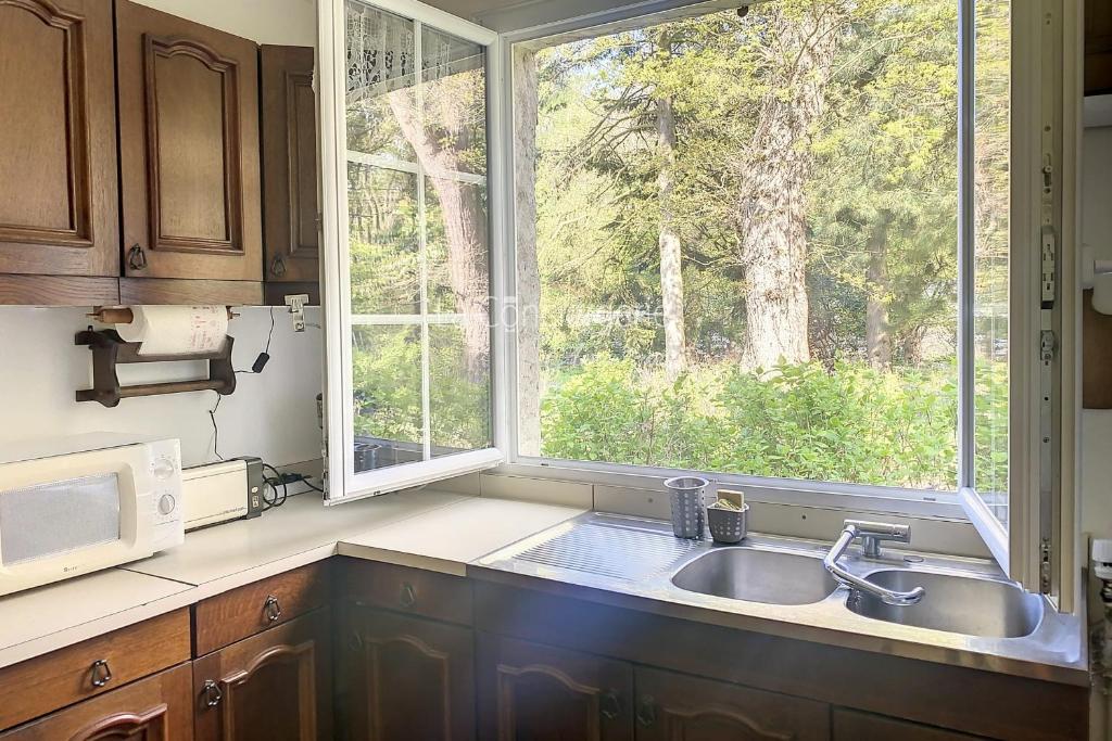 eine Küche mit Spüle und Fenster in der Unterkunft Mer & Bois de Cise Maison individuelle avec grand jardin in Ault