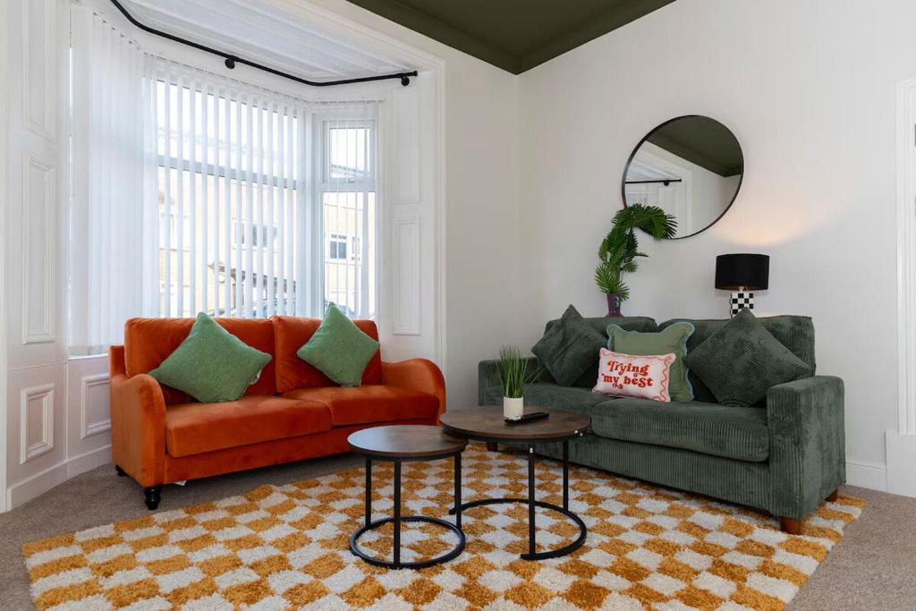 - un salon avec un canapé orange et un miroir dans l'établissement Spacious 3BR • WiFi • Parking • Contractor Stay, à Monkwearmouth