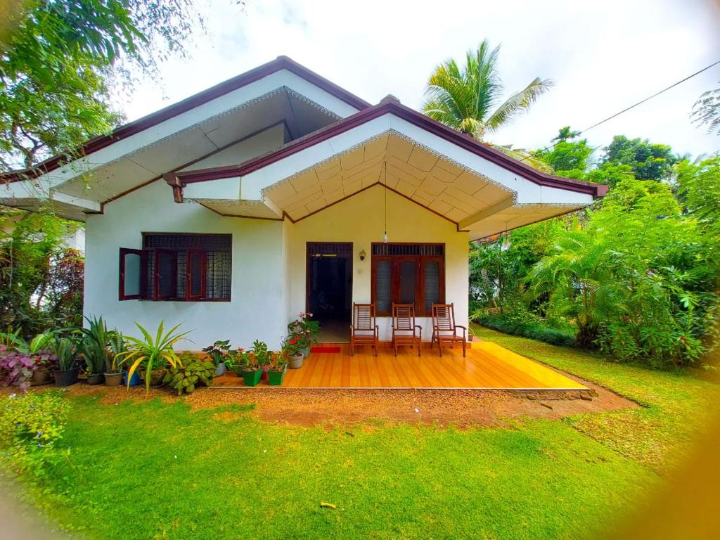 a small white house with chairs and a porch at Golden Breeze Villa in Beruwala