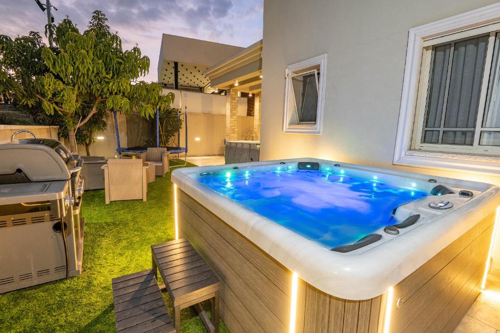 a jacuzzi tub in the middle of a yard at לה וילא - וילה מדהימה עם בריכה פרטית וג'קוזי in Sderot