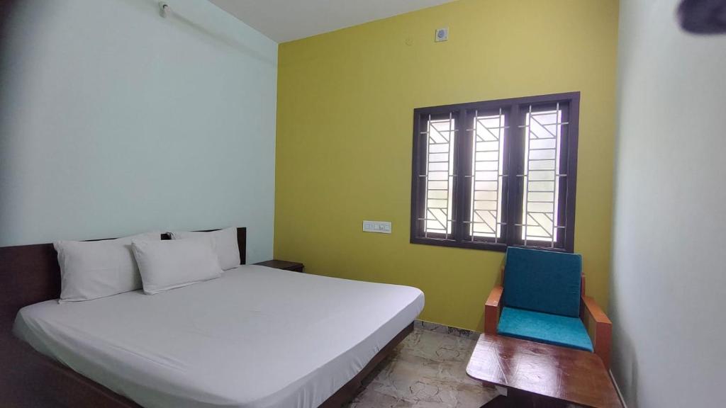 a bedroom with a white bed and a window at Aruna homes Thanjavur in Thanjāvūr
