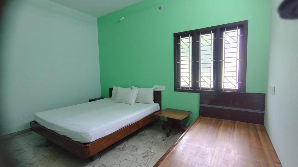 a small bedroom with a bed and a window at Aruna homes -Lakshana- Thanjavur in Thanjāvūr