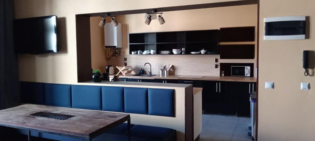 a kitchen with a sink and a wooden table at Rembrandt Hostel in Kraków