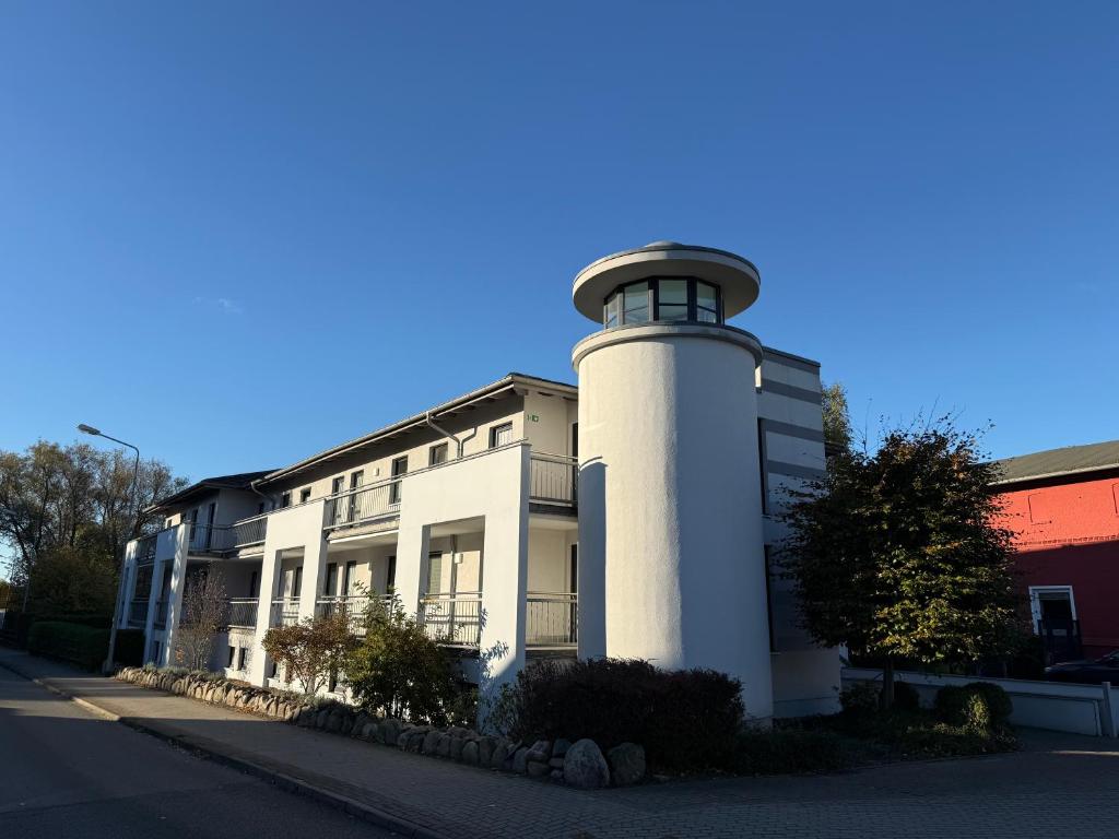 a white building with a lighthouse on the side of it at Moderne Ferienwohnung an der Ostsee im Haus Leuchtfeuer in Diedrichshagen