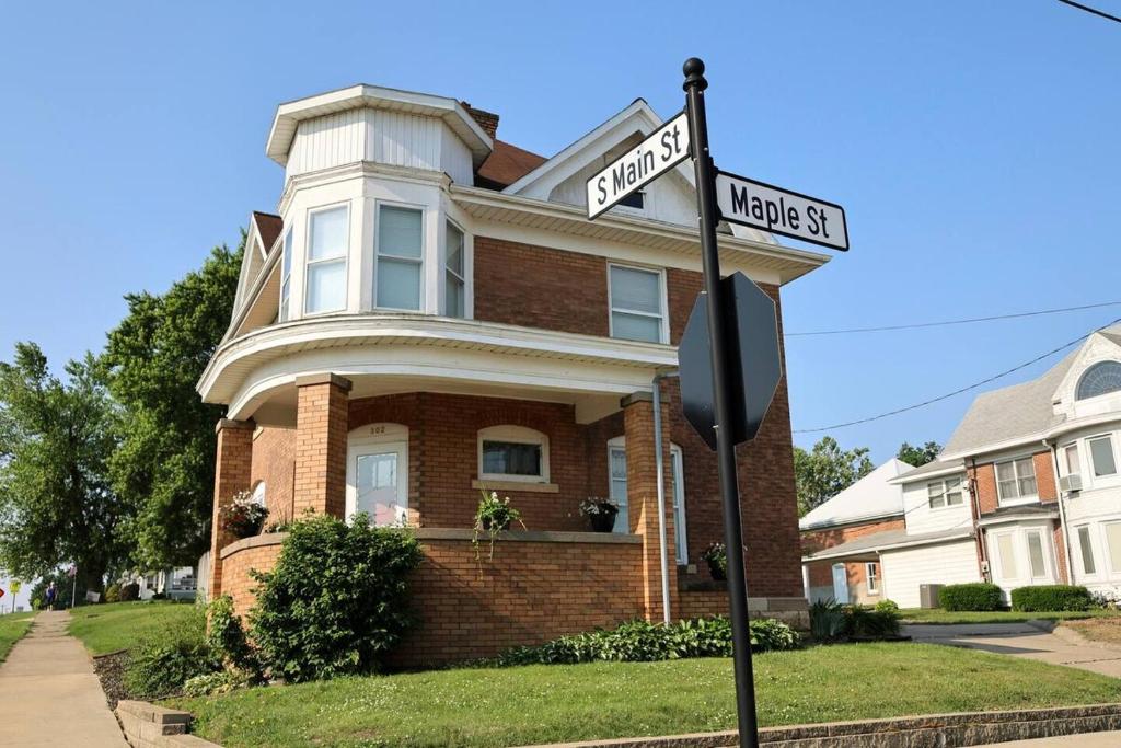 a street sign in front of a house at Riggs House Restored 1908 Home in Maquoketa