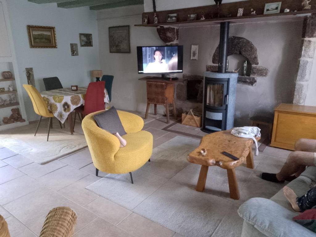 a living room with a yellow chair and a table at Bed and Cèpes in Busserolles
