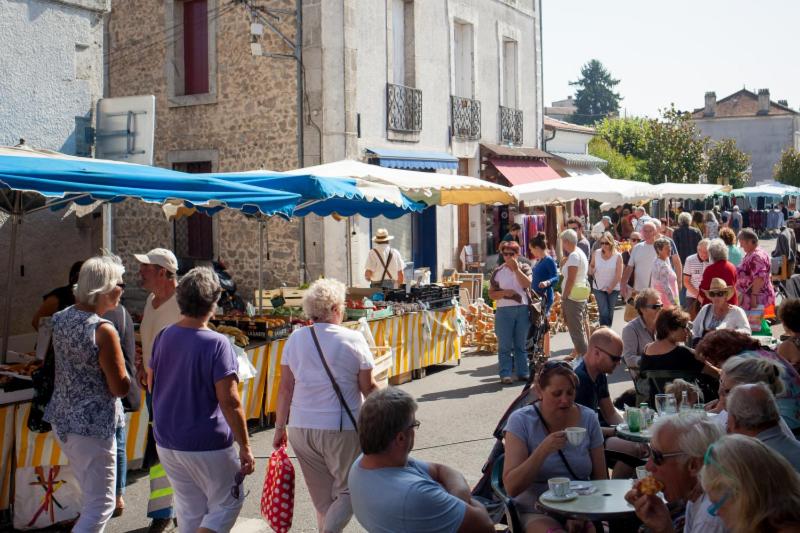 een menigte mensen die rondlopen op een openluchtmarkt bij Bed and Cèpes in Busserolles
