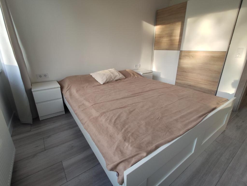 a bedroom with a large bed with a brown blanket at P Armino in Marijampolė