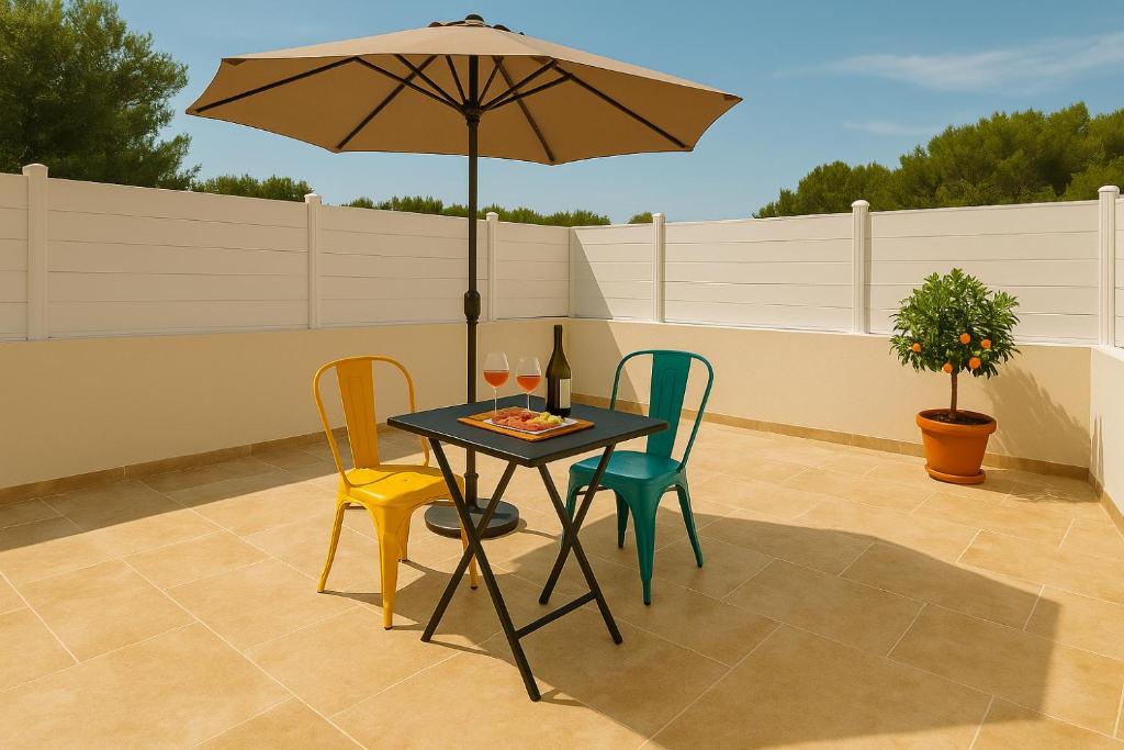 une table avec des chaises et un parasol sur une terrasse dans l'établissement La Dolce Vita Studios Clim Terrasse Privée Proche Draguignan, à Trans-en-Provence