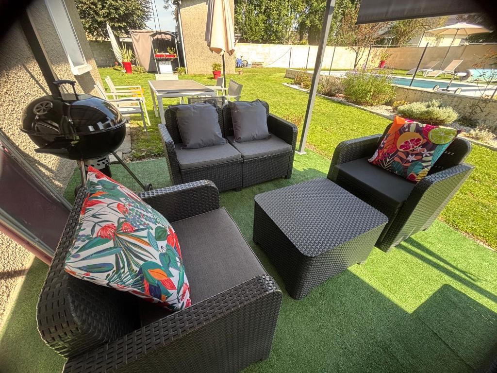 a patio with couches and chairs and a table at La Maison d'hôtes LA PUYERRE in Hours