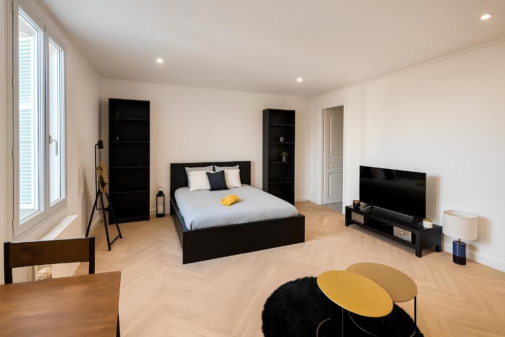 a bedroom with a bed and a flat screen tv at Corderie in Rouen