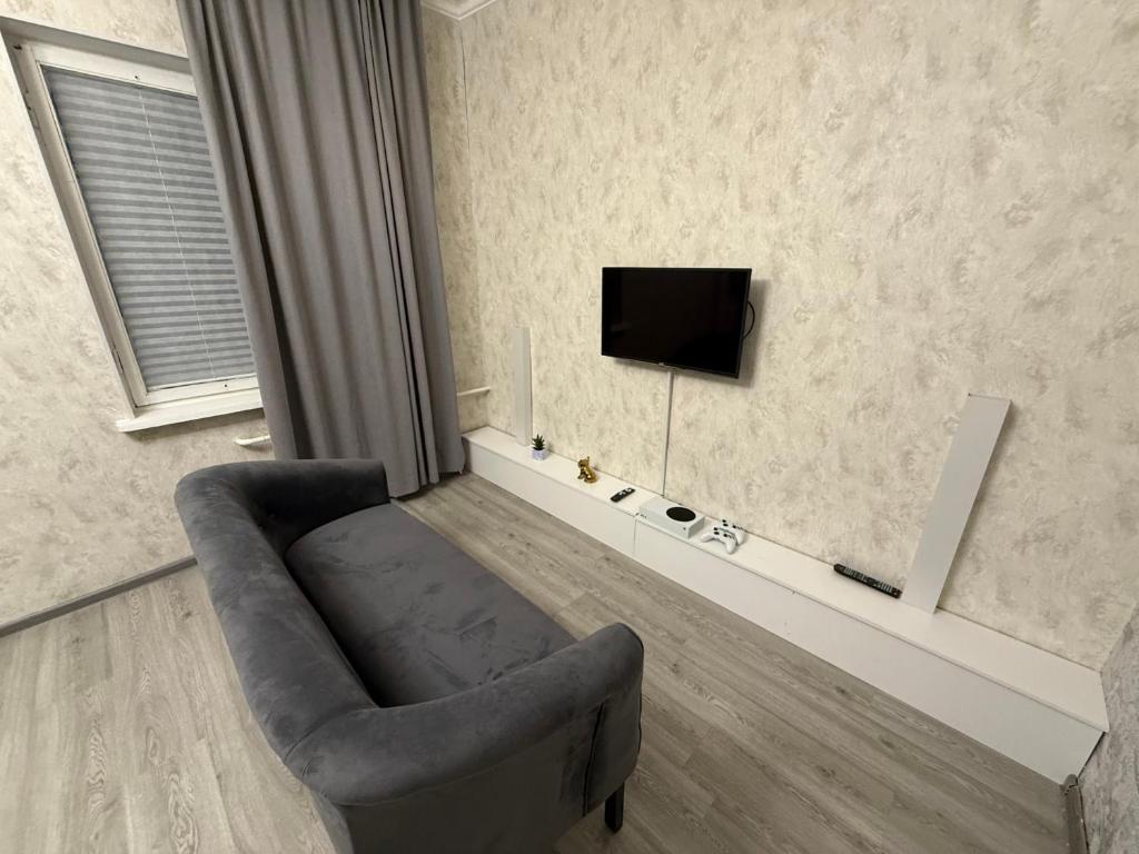 a living room with a chair and a television at Romantic place in Darkhon