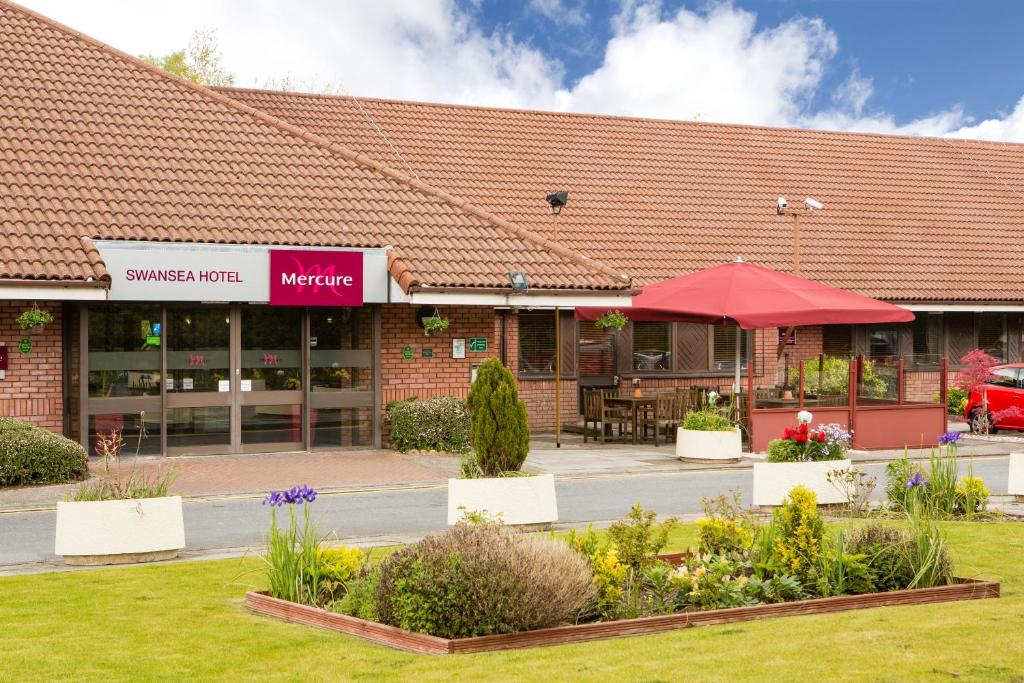 un edificio con un patio con flores delante en Mercure Swansea Hotel, en Swansea