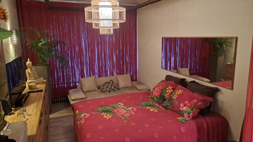 a bedroom with a red bed with a red blanket at BeautyD Private Room centrum Gullegem-Kortrijk in Wevelgem