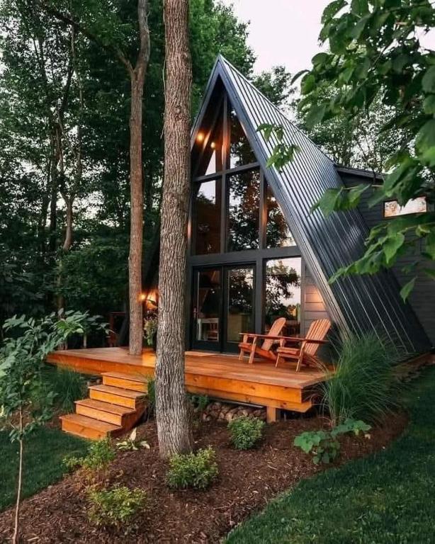 a small cabin with a porch and a tree at A-Frame Villas & Lodges LLC in Kitengela 