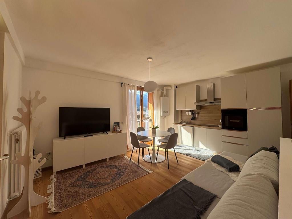 a living room with a couch and a tv and a kitchen at Siera View Apartment - Comfort e Relax a Sappada in Ecche