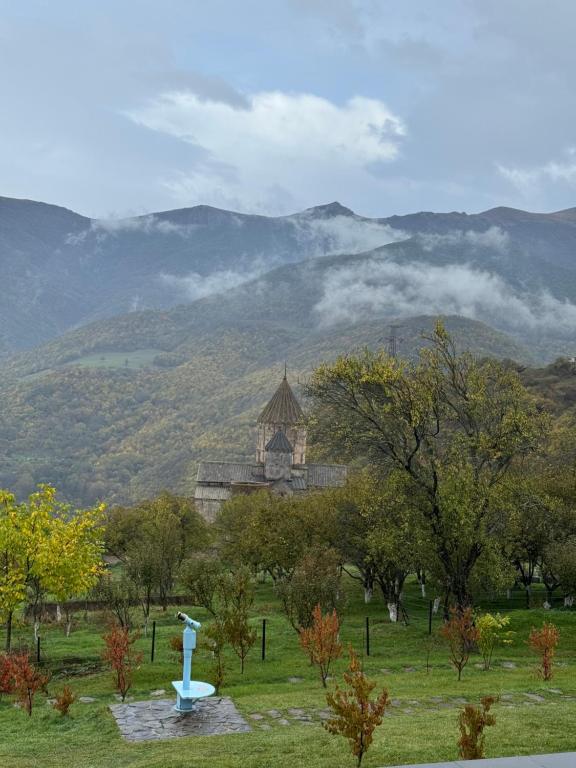 a building in a field with mountains in the background at AlexMila in Tatʼev
