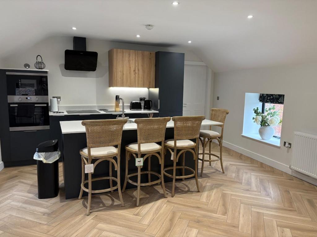 a kitchen with a bar with chairs and a counter top at The Old Bakehouse, central historical Beverley in Beverley