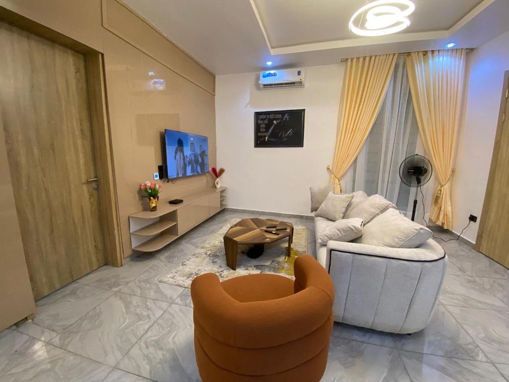 a living room with an orange chair and a couch at DLA Lux Studio in Ikota, Lagos in Lekki