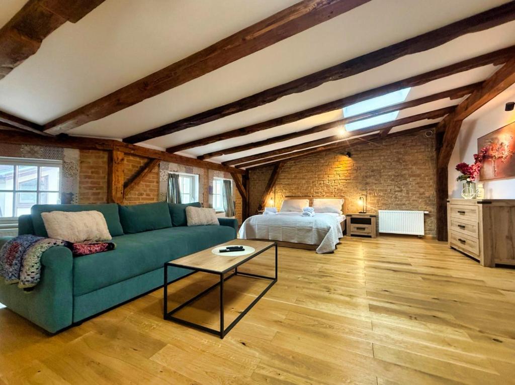 a living room with a green couch and a bed at Siesta by Rentoom in Toruń