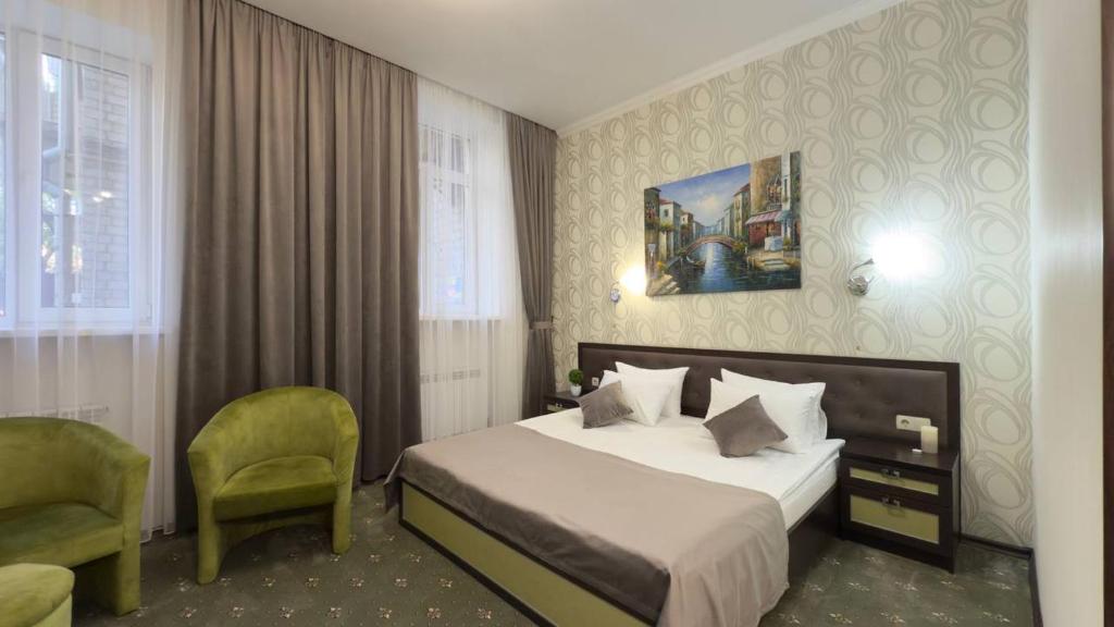 a hotel room with a bed and a chair at Hotel Voyage in Kharkiv