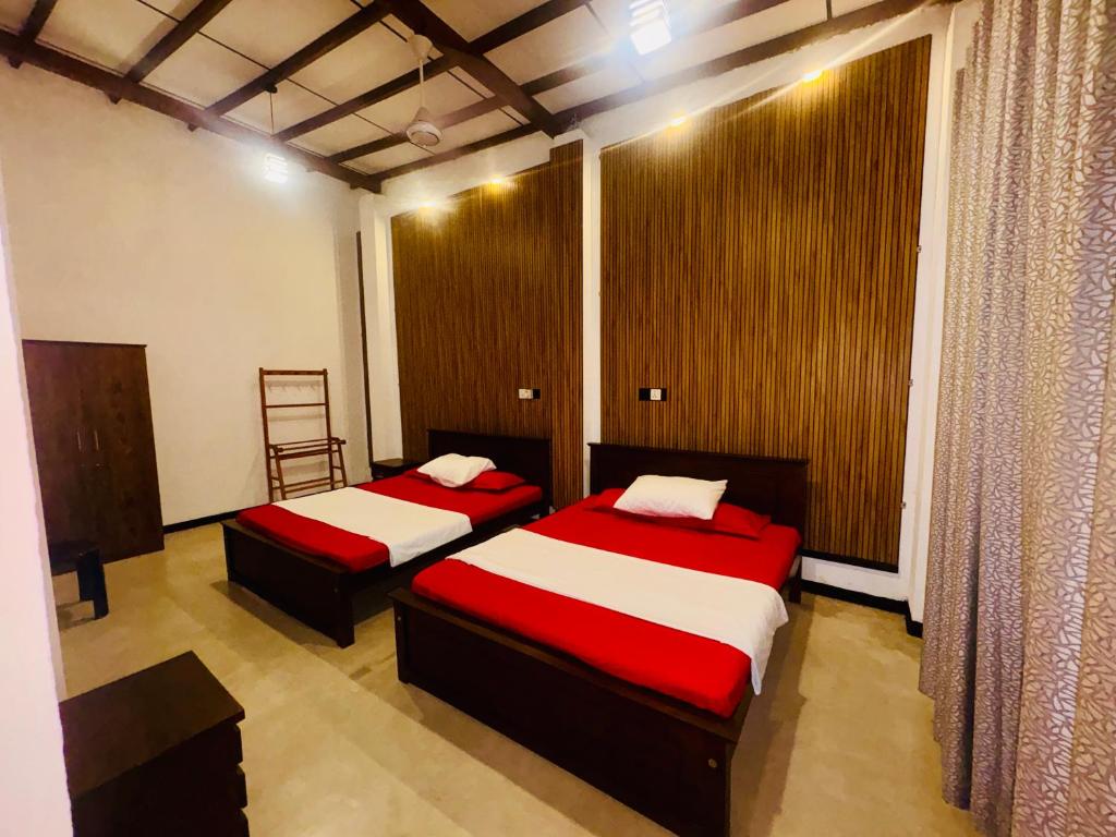 a bedroom with two beds with red and white sheets at Shehan Villa in Beruwala