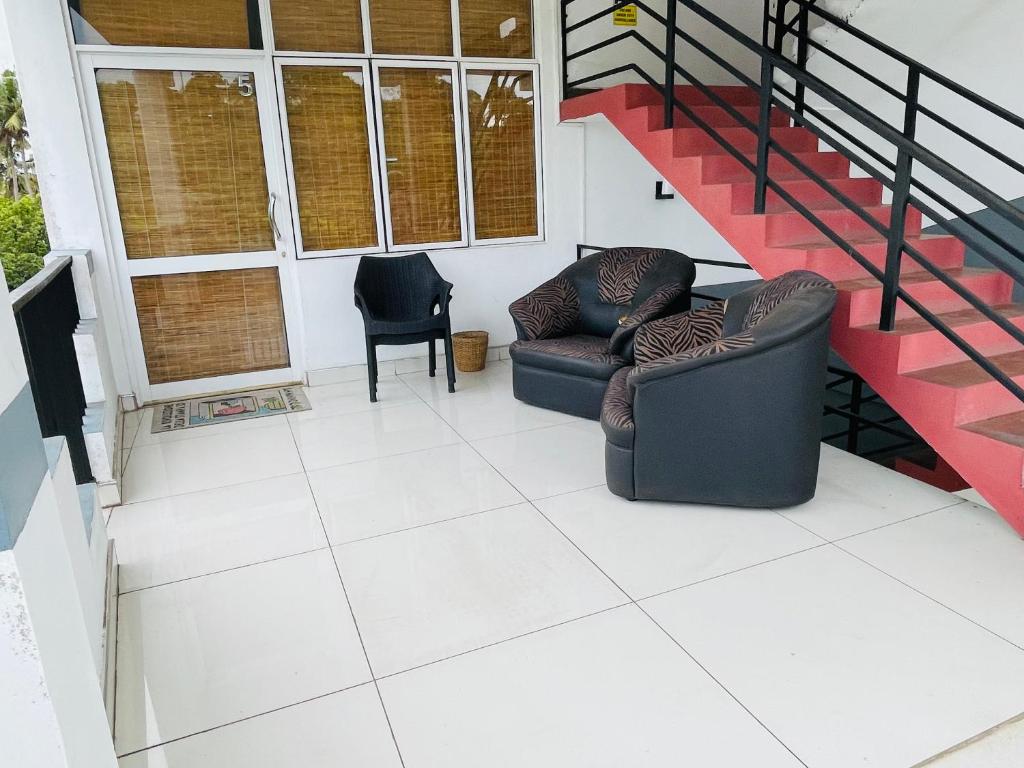 sala de estar con 2 sillas y escalera en Be Happy, en Weligama