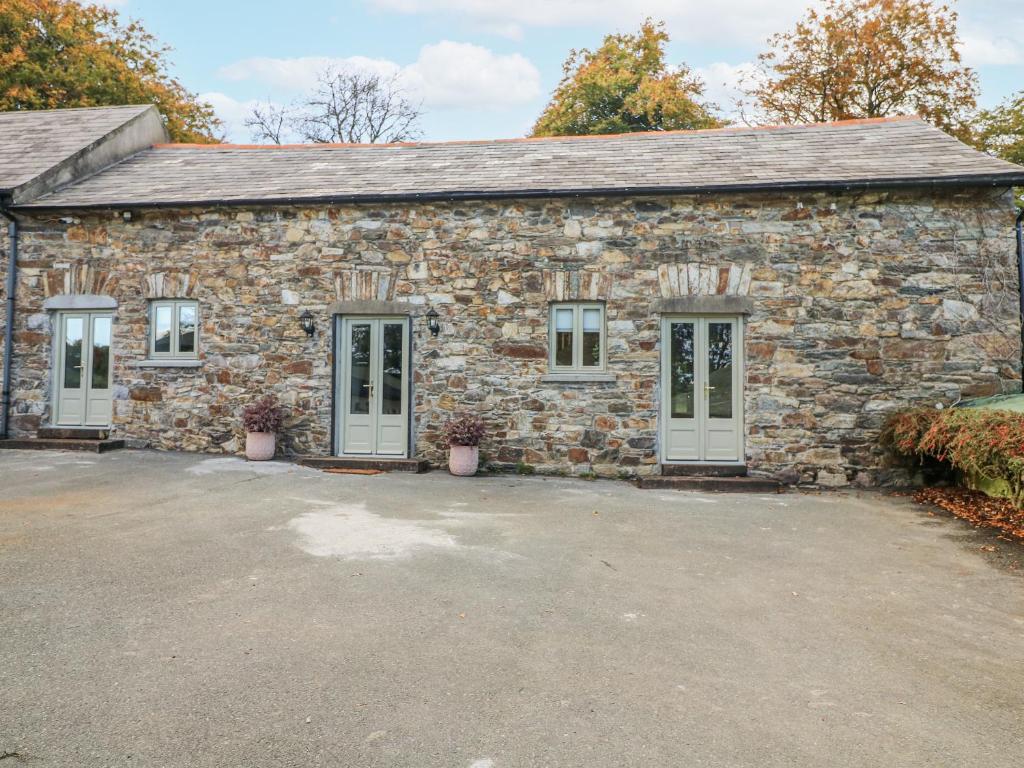 a stone building with two doors and a car lot at Robins Rest at The Lodge in McGrathʼs Cross Roads