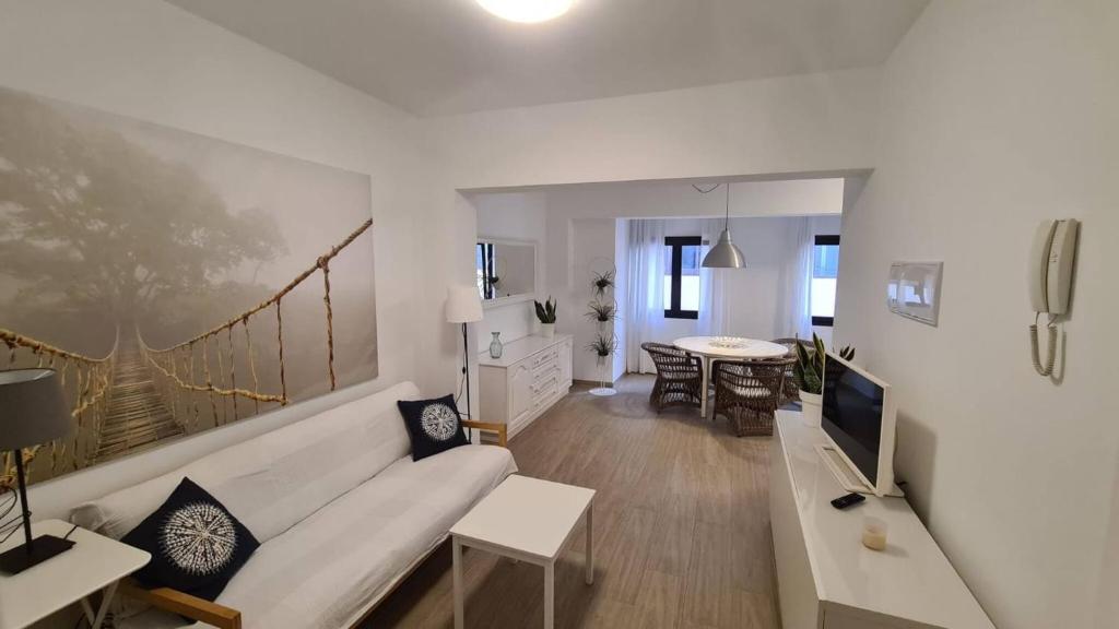 ein Wohnzimmer mit einem weißen Sofa und einem Fernseher in der Unterkunft Arrecife Apartamento centrico in Arrecife
