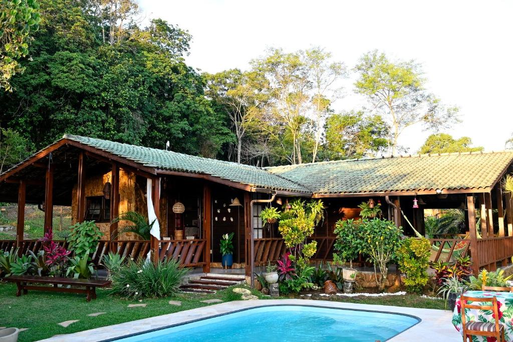a house with a swimming pool in front of it at Chalé Oxossi in Maricá