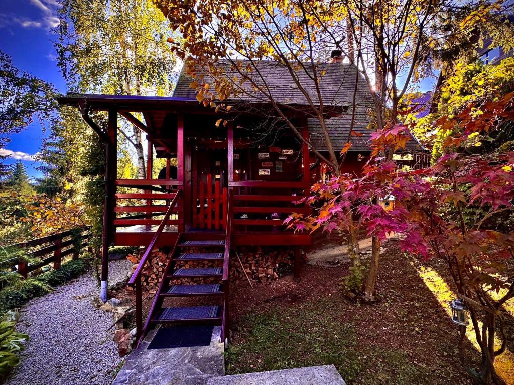 a red cabin with a staircase leading up to it at Zlatarsko Miriste in Nova Varoš