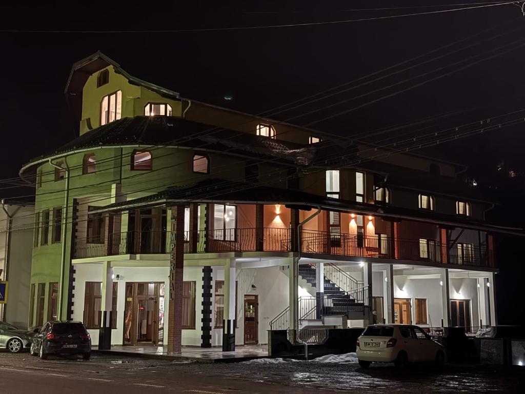 un edificio verde con coches aparcados delante de él en Imperial, en Moisei