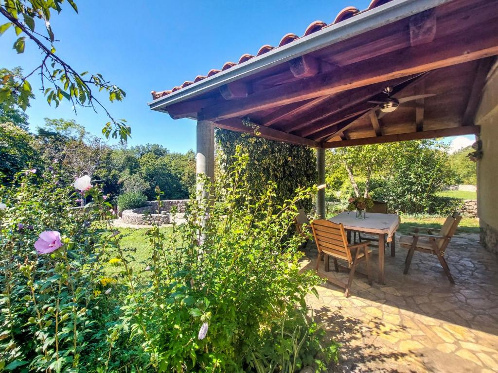 un patio avec une table et des chaises sous une pergola dans l'établissement Holiday Home Ljudevit by Interhome, à Dobrinj