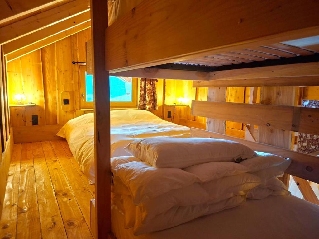 Dos literas en una habitación con paredes de madera. en Cabane Insolite de la Semine, en La Pesse