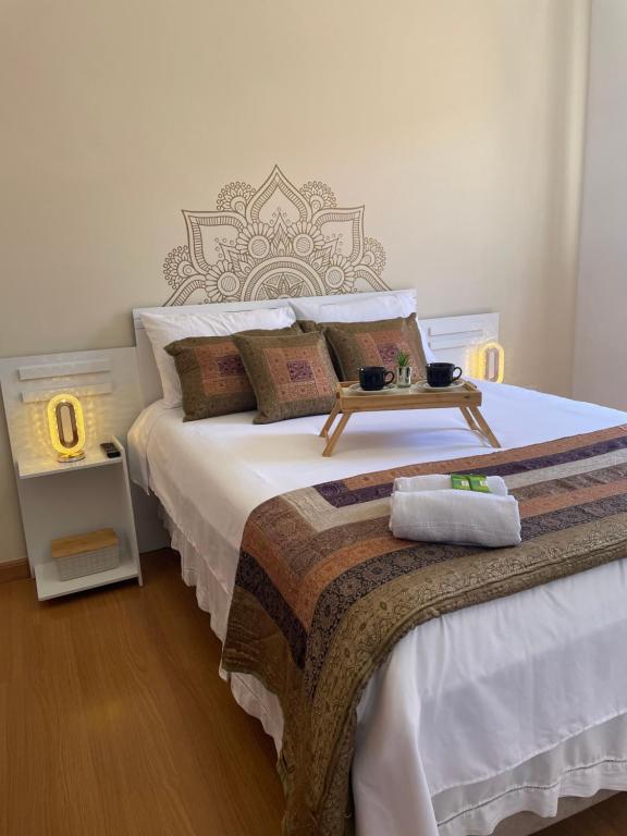 a bedroom with a large bed with a table on it at Apartamento Vista da Serra in Poços de Caldas