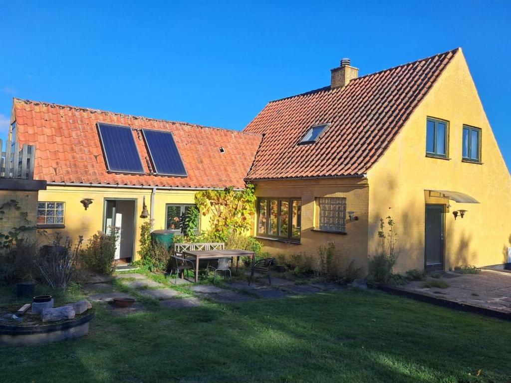 a yellow house with solar panels on the roof at Holiday Home Amlethus - 375m from the sea by Interhome in Allinge