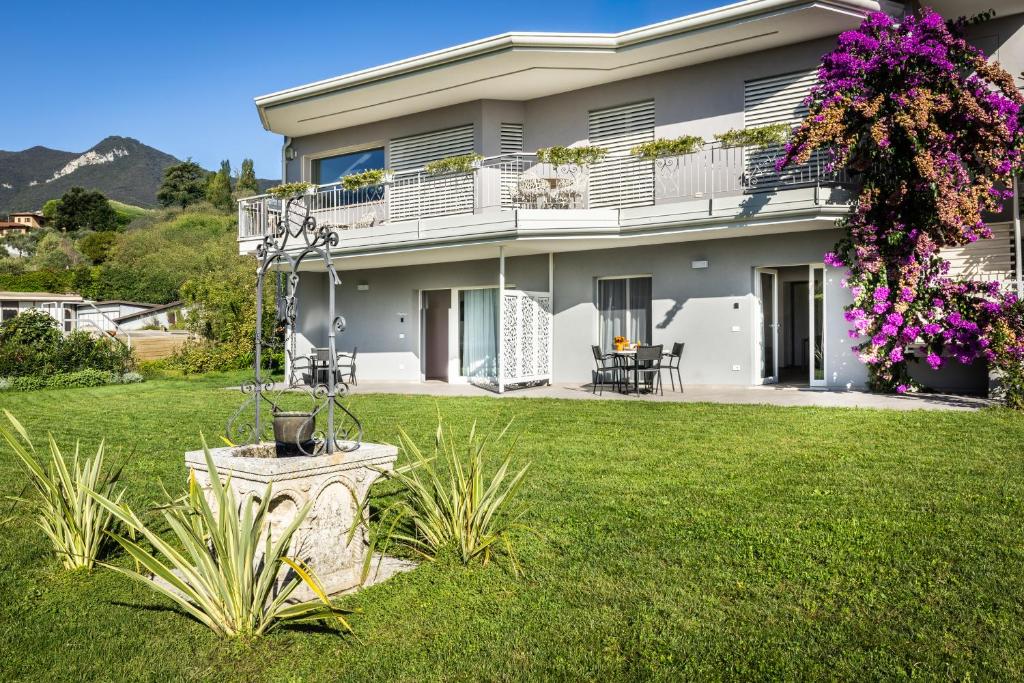 a large house with a green yard with flowers at Holiday Apartments Campoverde in Salò