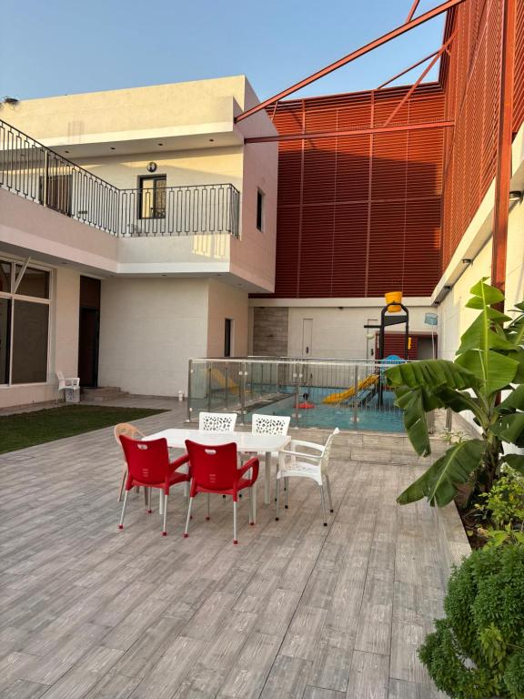 a patio with red chairs and a table in front of a building at فيلا غريس الجديدة 3 غرف نوم ومسبح in Jeddah