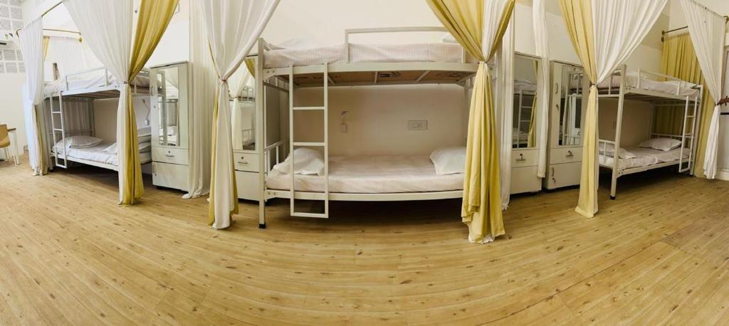 una habitación con cuatro literas con cortinas amarillas en Kareema's Hostel, en Chennai