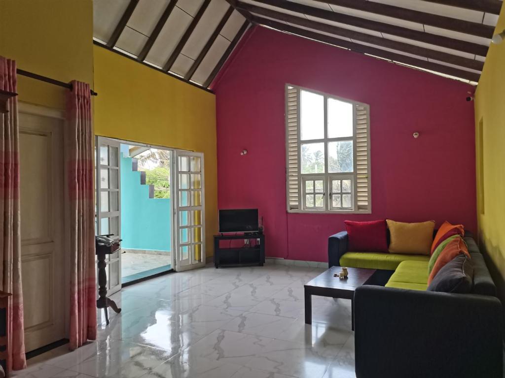 a living room with a couch and colorful walls at Ceylon Traveller Homestay in Panadura