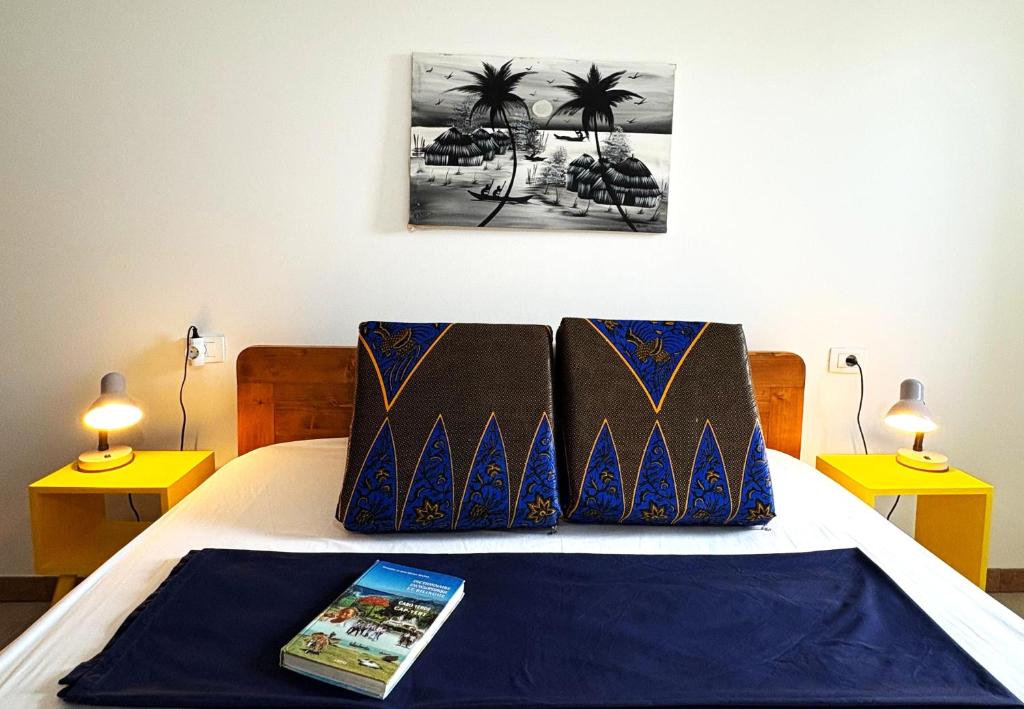 een bed met twee kussens en een boek erop bij Sal Princess in Santa Maria