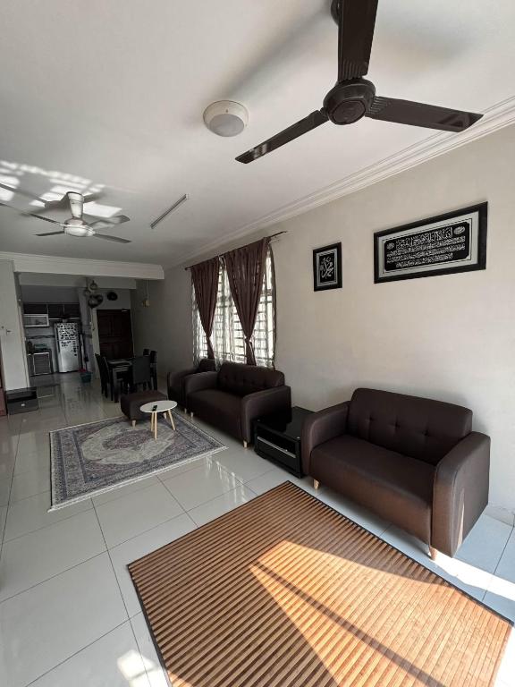 a living room with couches and a ceiling fan at SBFAM HOMESTAY SHAH ALAM SEKSYEN 7 - NEAR i-CITY AND UITM in Shah Alam
