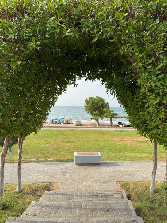 a bench sitting under an arch in a park at Beachside Room in Muscat in Muscat
