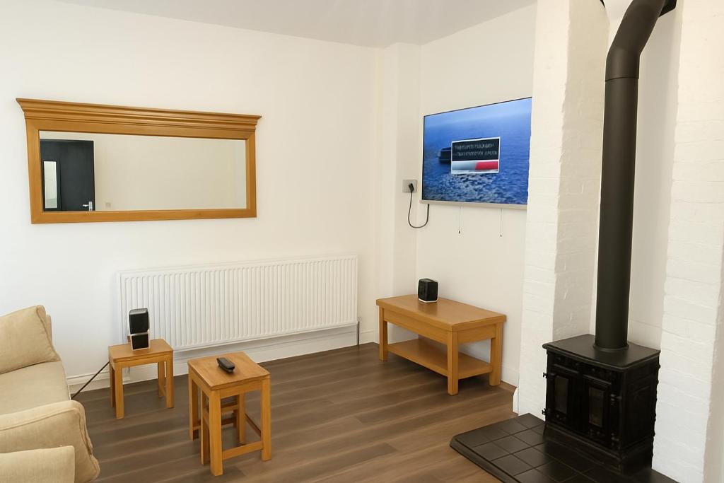 a living room with a wood stove and a couch at Llangollen - House - Sleeps 7 - Garden in Glyn-Ceiriog