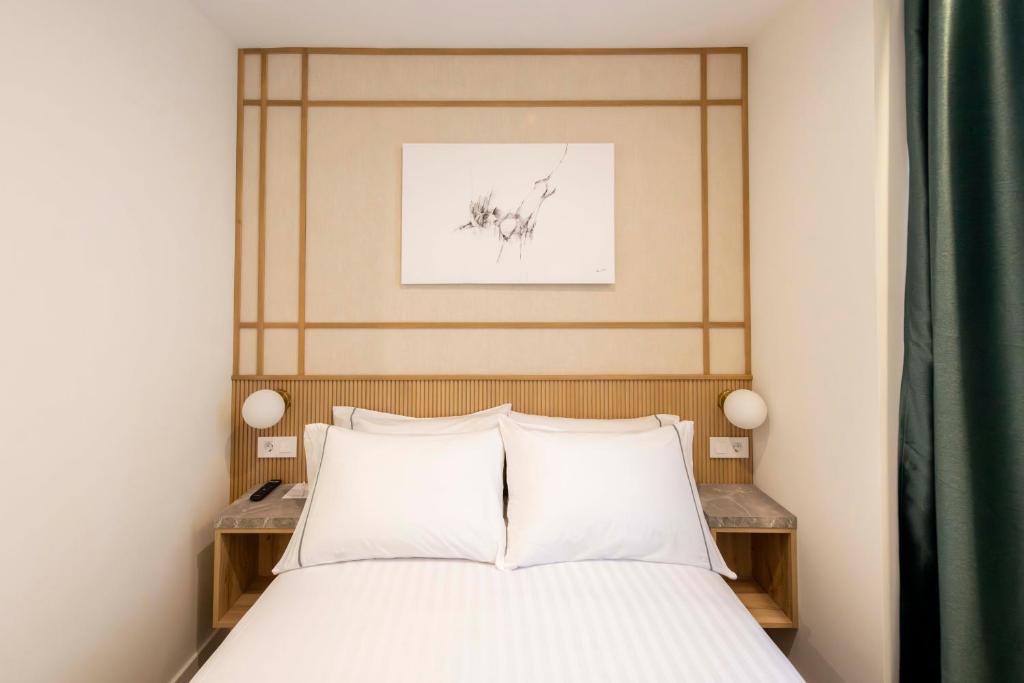 a bed with two white pillows in a bedroom at Silken Apartamentos Goya in Oviedo